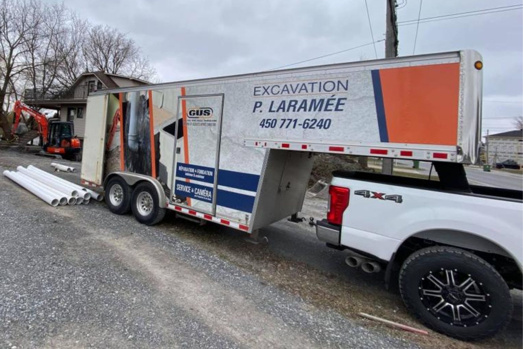 Véhicule utilitaire et remorque stationnés sur un site de travaux résidentiels avec matériaux au sol  à Saint-Hyacinthe