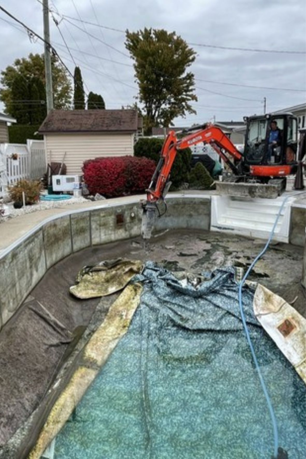 Travaux en cours dans une excavation circulaire avec équipement mécanique visible sur un site résidentiel au Québec